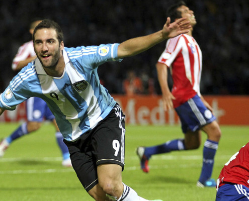 Argentina's Gonzalo Higuain (L) celebrates after scoring his team's second goal as Paraguay's Paulo Da Silva (R) reacts during their World Cup 2014 qualifying soccer match in Cordoba September 7, 2012.          REUTERS/Enrique Marcarian (ARGENTINA - Tags: SPORT SOCCER)