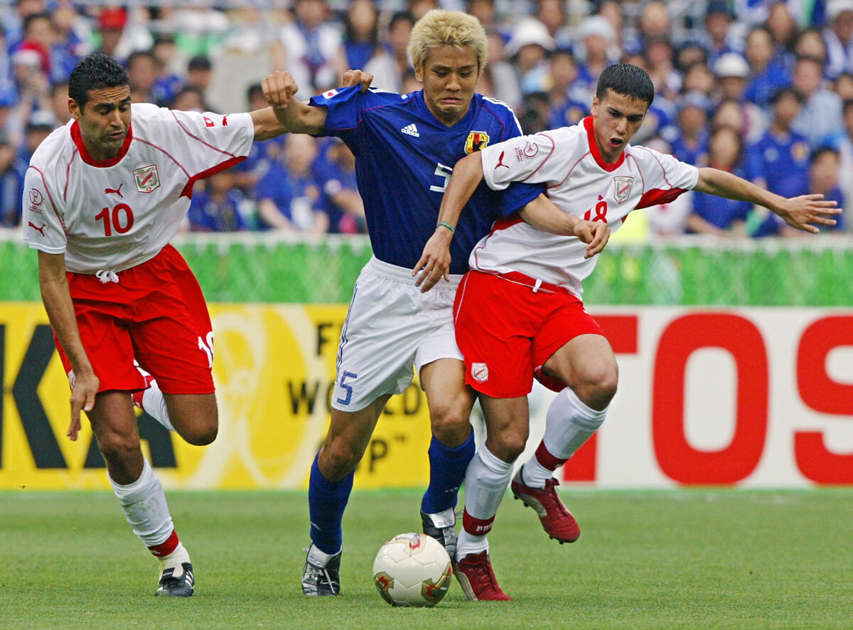 Japan's midfielder Junichi Inamoto attemps to keep Tunisia's midfielder Kaies Ghodhbane (L) and midfielder Slim Ben Achour (R) at a distance to get to the ball during match 45 group H of the 2002 FIFA World Cup Korea Japan 14 June, 2002 in Osaka, Japan.AFP PHOTO PEDRO UGARTE (Photo by PEDRO UGARTE / AFP)