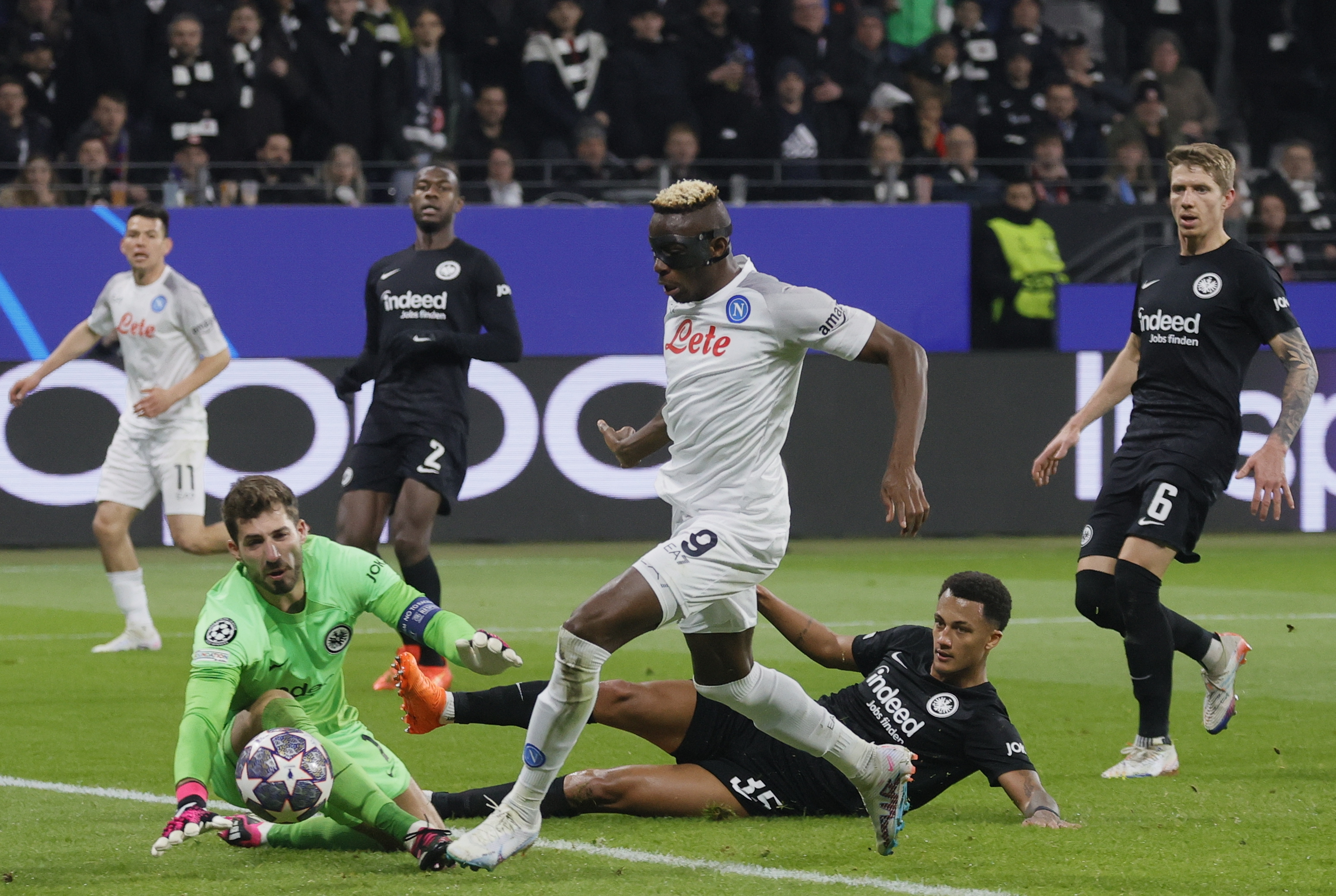 Frankfurt (Germany), 21/02/2023.- Napoli's Victor Osimhen (C) in action against Frankfurt's goalkeeper Kevin Trapp (L) and Tuta (R) during the UEFA Champions League, Round of 16, 1st leg between Eintracht Frankfurt and SSC Napoli in Frankfurt, Germany, 21 February 2023. (Liga de Campeones, Alemania) EFE/EPA/Ronald Wittek
